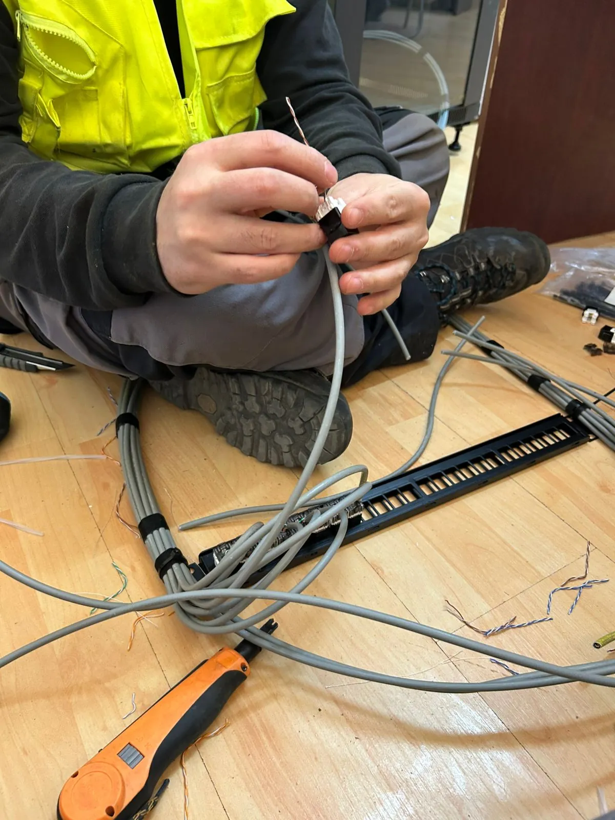 Técnico preparando cables de red en el suelo antes del montaje